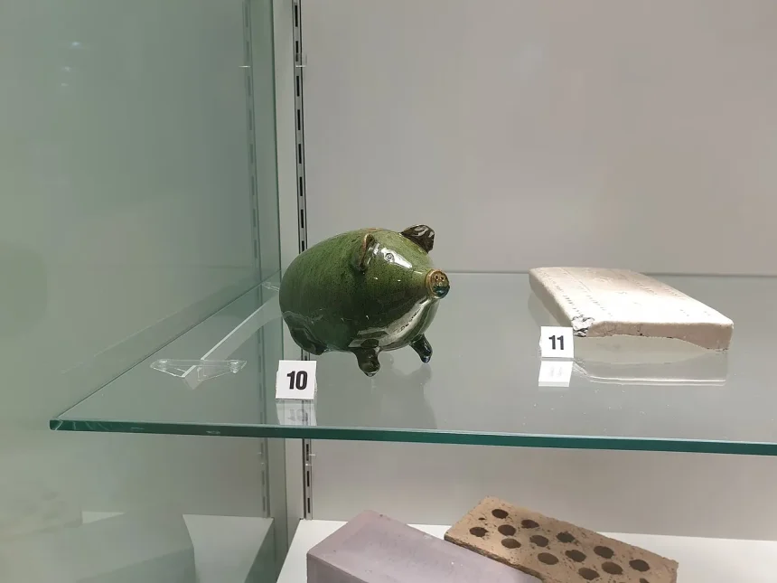 A traditional piggy bank displayed in a museum, a symbol of basic saving habits